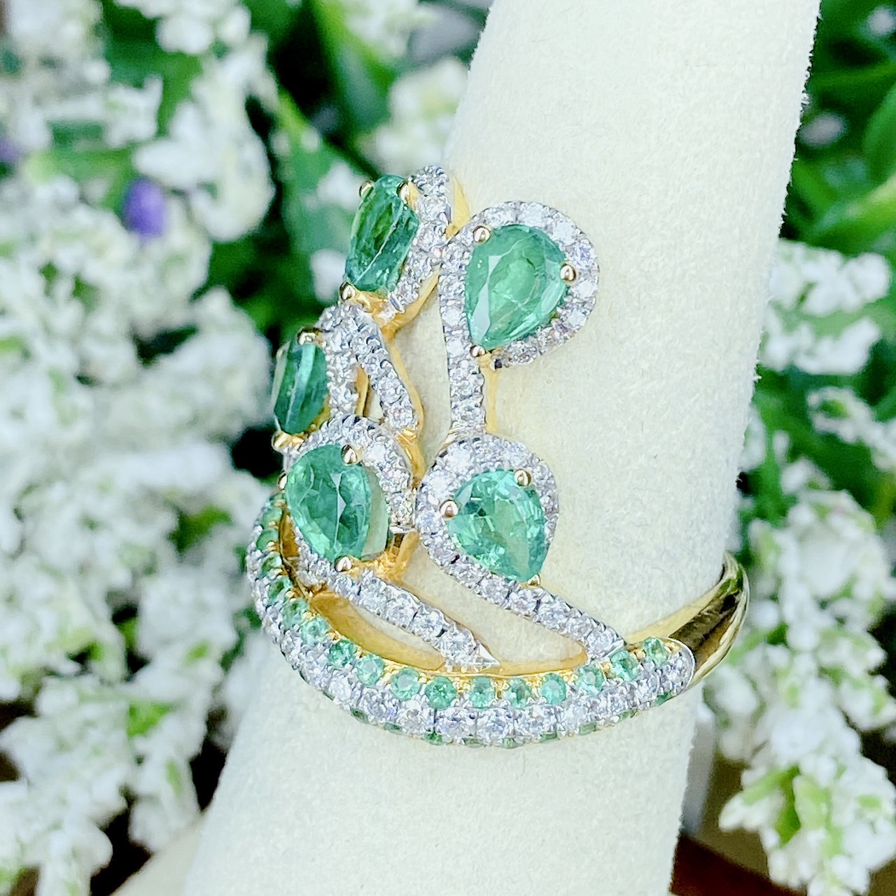 แหวนเพชรไขว้ล้อมมรกต The ring rotates upward. โดยฝังเพชรแถวสลับมรกตที่ตัวเรือนด้านล่าง แล้วค่อยหมุนไต่ระดับขึ้นด้านบนเป็นเหมือนสวนดอกไม้ Floral motif