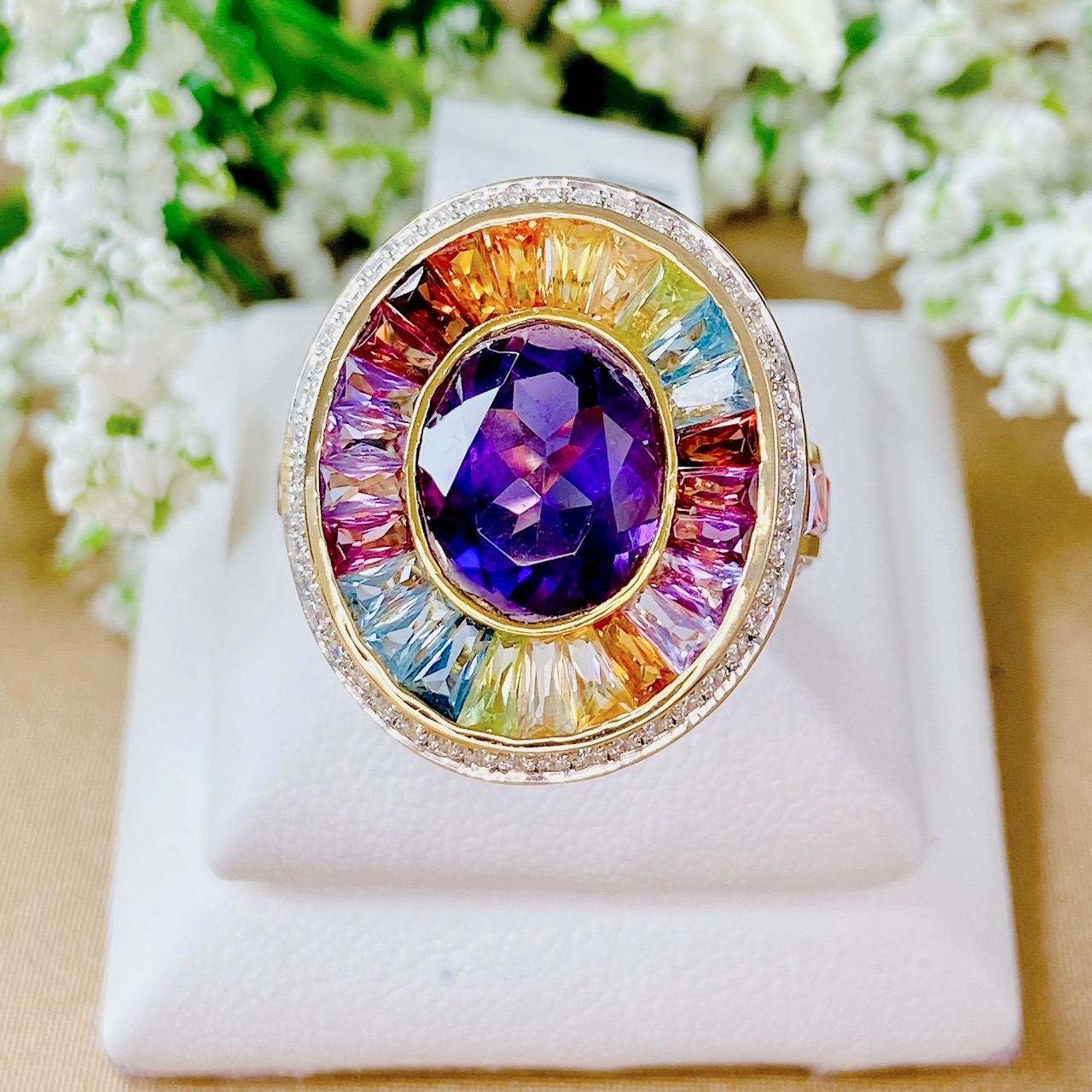 แหวนพลอยมัลติเหลี่ยมแทปเปอร์ล้อมอเมทิสต์สีม่วง ฝังเพชรล้อมเป็น Surprise Diamond ประดับบ่าด้านข้างด้วยอเมทิสต์เหลี่ยมปริ้นเซส ตัดขอบด้วยเพชรน้ำ100