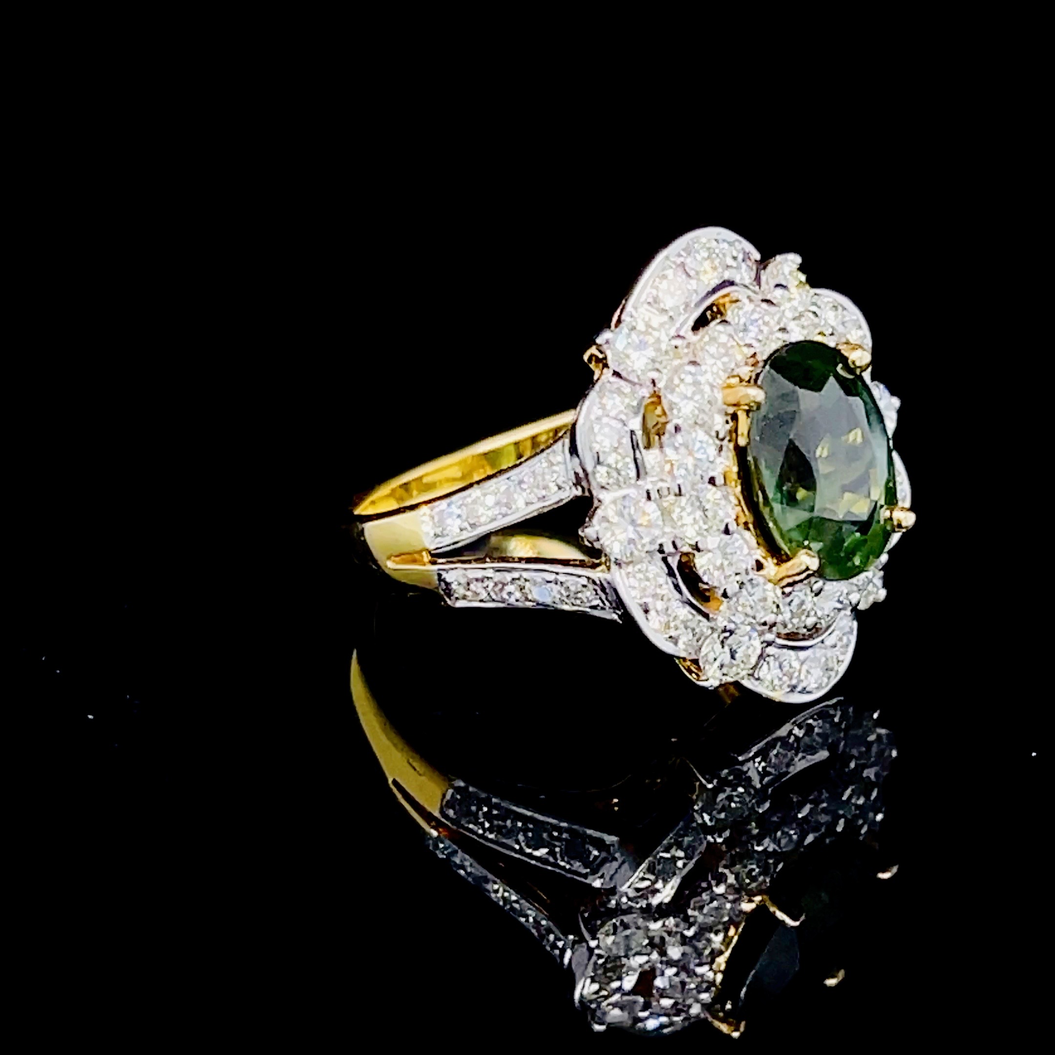 แหวนพลอยเขียวส่องประดับเพชร (Design Cocktail Ring) เขียวส่องเม็ดมาใหม่ สีสวยเหลี่ยมเล่นไฟ เจียระไนแบบเหลี่ยมเพชรรูปไข่ (Oval Shape) ล้อมเพชรสวย ไฟเต็มทุกเม็ด