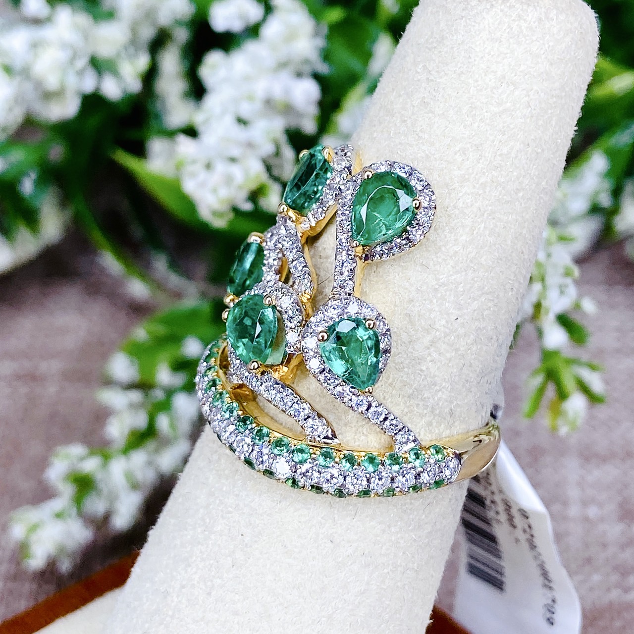 แหวนเพชรไขว้ล้อมมรกต The ring rotates upward. โดยฝังเพชรแถวสลับมรกตที่ตัวเรือนด้านล่าง แล้วค่อยหมุนไต่ระดับขึ้นด้านบนเป็นเหมือนสวนดอกไม้ Floral motif