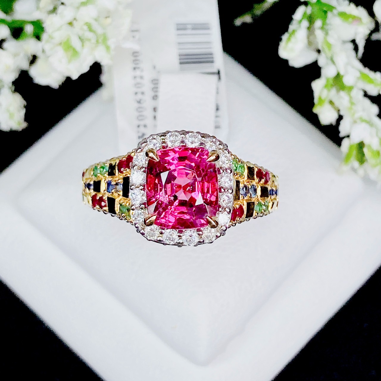 Pink Spinel (สปิเนลสูงศักดิ์) รูปทรงหมอน เจียระไนแบบเหลี่ยมผสม (จะให้แสงระยิบระยับที่สวยมากๆ) ล้อมด้วยเพชรน้ำ100 ฝังตรงกะเปาะด้านข้าง บ่าฝังพลอยทับทิมพม่า/ไพลินซีลอน/มรกตแซมเบีย สลับหว่างกับตัวเรือนทอง ทรงชูไม่สูงมาก ใส่แล้วโอบรับกับนิ้ว
