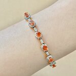 สร้อยข้อมือพลอยซองเจียล้อมเพชรเรียงแถว 7 เม็ด สีส้ม รูปร่างไข่ เจียระไน Mixed cut สี ส้มแดง ความสะอาด VS