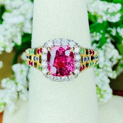 Pink Spinel (สปิเนลสูงศักดิ์) รูปทรงหมอน เจียระไนแบบเหลี่ยมผสม (จะให้แสงระยิบระยับที่สวยมากๆ) ล้อมด้วยเพชรน้ำ100 ฝังตรงกะเปาะด้านข้าง บ่าฝังพลอยทับทิมพม่า/ไพลินซีลอน/มรกตแซมเบีย สลับหว่างกับตัวเรือนทอง ทรงชูไม่สูงมาก ใส่แล้วโอบรับกับนิ้ว